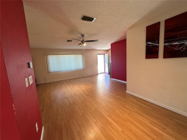 empty room with ceiling fan, a textured ceiling, and light hardwood / wood-style flooring