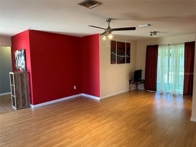 spare room featuring ceiling fan, wood-type flooring, and a textured ceiling