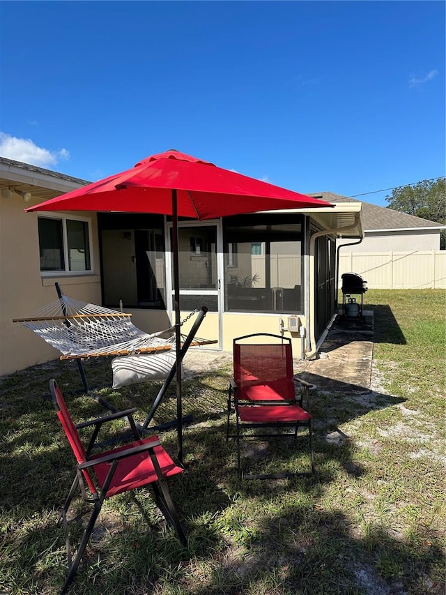 back of property with a sunroom and a yard