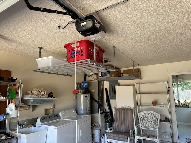 laundry area with a textured ceiling, sink, washing machine and dryer, and water heater