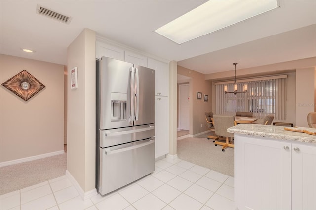 kitchen with pendant lighting, light carpet, white cabinets, stainless steel refrigerator with ice dispenser, and a chandelier