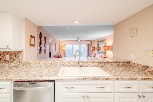 kitchen featuring dishwasher, backsplash, white cabinets, sink, and ceiling fan