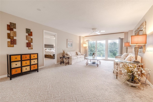 living room featuring carpet, a textured ceiling, and ceiling fan