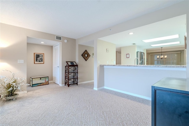 kitchen featuring light carpet, hanging light fixtures, stainless steel refrigerator, and a chandelier