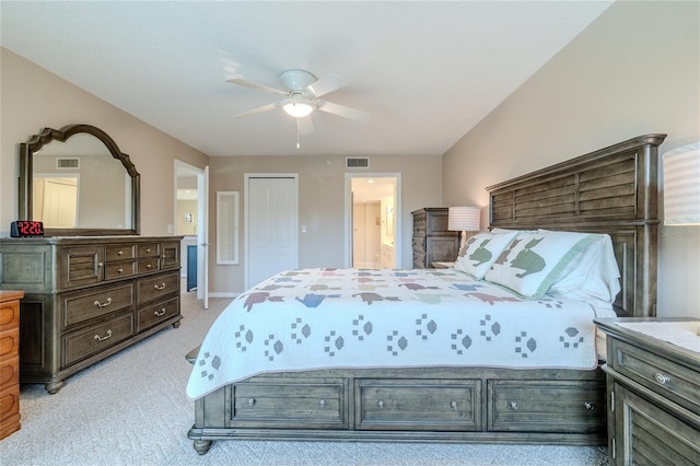 carpeted bedroom with a closet, ensuite bath, and ceiling fan