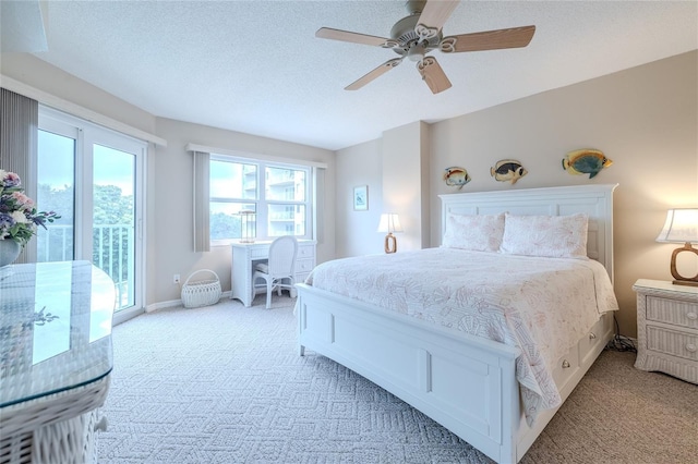 carpeted bedroom featuring access to exterior, ceiling fan, and a textured ceiling