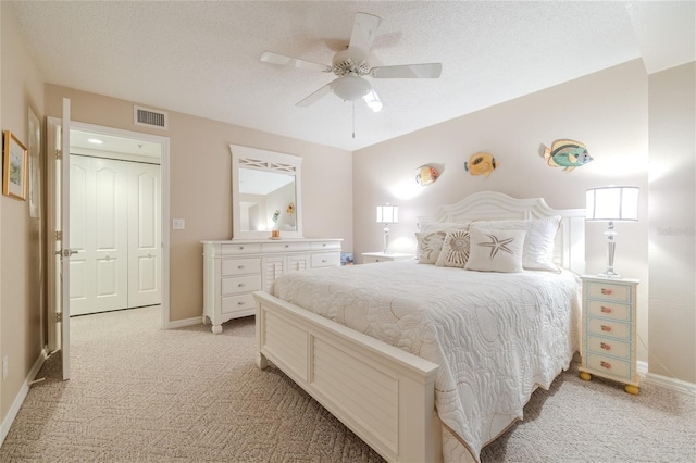 carpeted bedroom featuring ceiling fan, a textured ceiling, and a closet