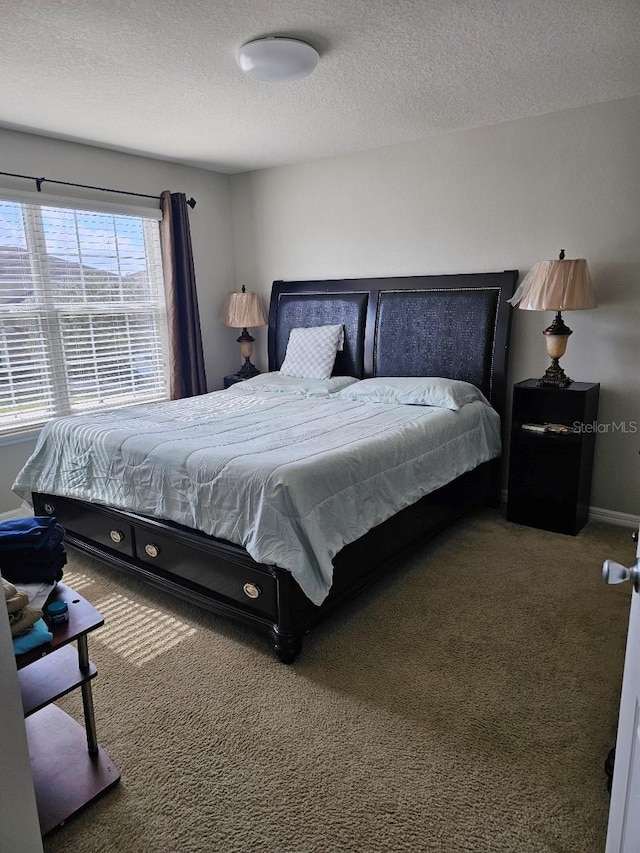 bedroom featuring dark carpet and a textured ceiling