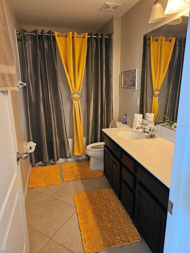 full bathroom with shower / bath combination with curtain, tile patterned floors, vanity, a textured ceiling, and toilet