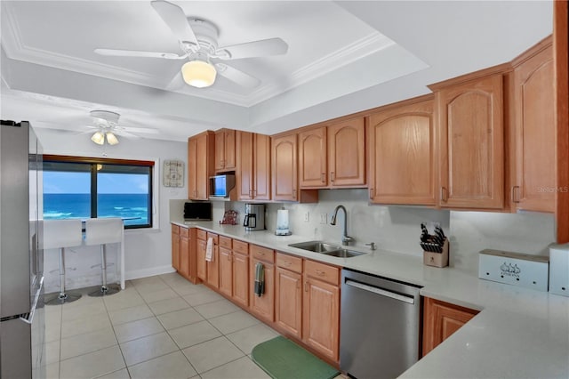 kitchen with ceiling fan, sink, appliances with stainless steel finishes, light tile patterned floors, and ornamental molding