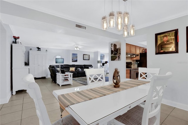 tiled dining room with ceiling fan and ornamental molding