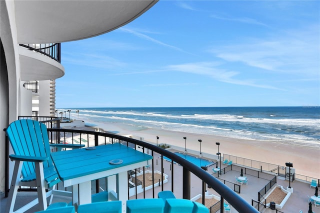 balcony featuring a view of the beach and a water view