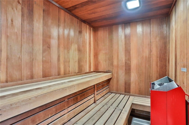 view of sauna with wooden ceiling and wooden walls