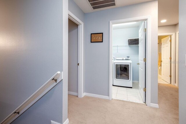 hallway featuring light carpet and washer / clothes dryer