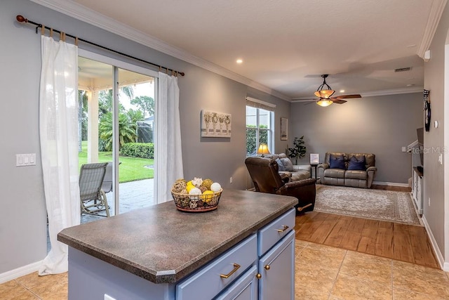 kitchen with a center island, light hardwood / wood-style flooring, ceiling fan, and crown molding