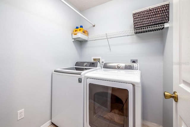 washroom featuring a textured ceiling and washing machine and dryer