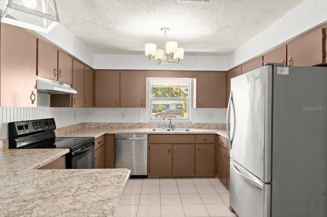 kitchen featuring appliances with stainless steel finishes, a textured ceiling, sink, pendant lighting, and a chandelier