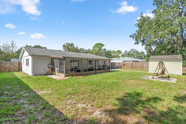 back of house with a yard, a storage shed, and a sunroom