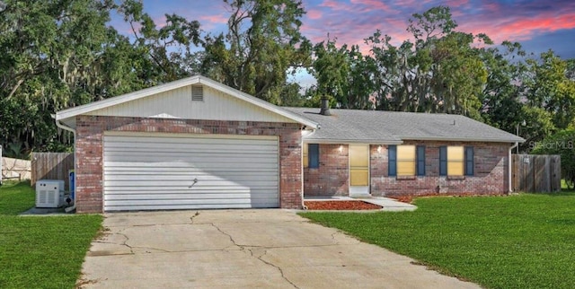 ranch-style house with a yard and a garage