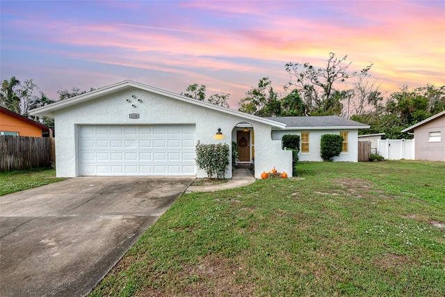 ranch-style house with a garage and a lawn