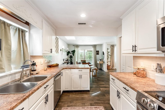 kitchen featuring dark hardwood / wood-style flooring, stainless steel appliances, white cabinetry, and sink