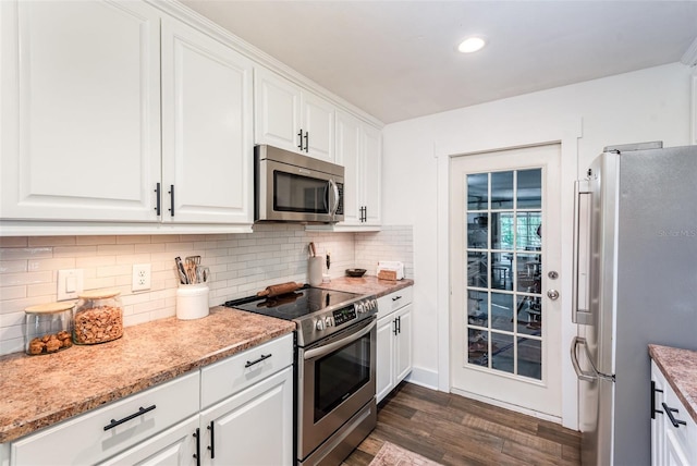 kitchen featuring backsplash, white cabinets, dark hardwood / wood-style floors, appliances with stainless steel finishes, and light stone counters