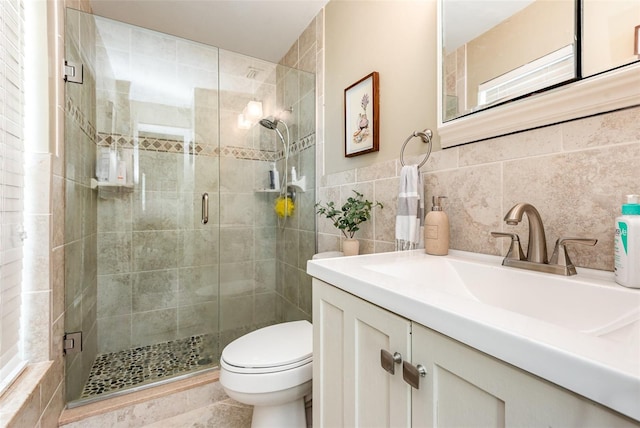 bathroom with toilet, vanity, tile walls, and walk in shower