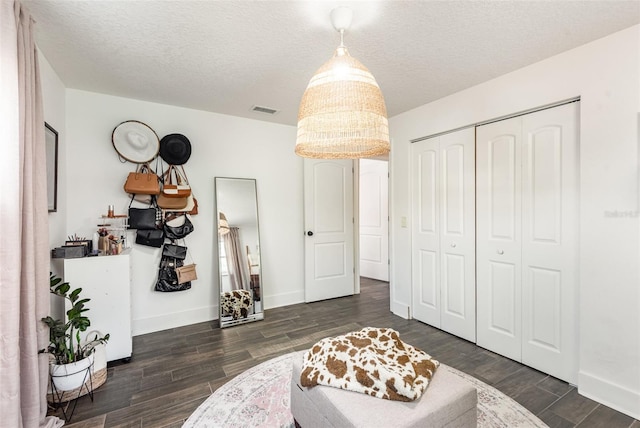 interior space featuring a textured ceiling and dark hardwood / wood-style floors