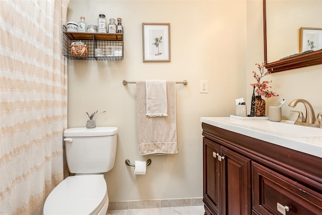 bathroom with tile patterned flooring, vanity, and toilet