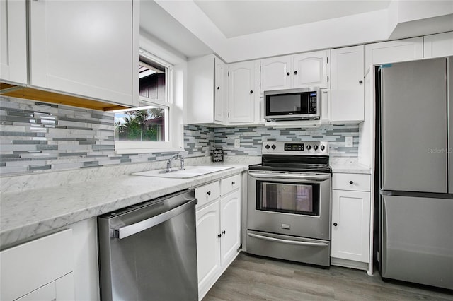 kitchen featuring backsplash, dark wood-type flooring, sink, white cabinetry, and stainless steel appliances