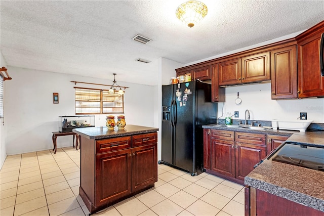 kitchen with black fridge with ice dispenser, a textured ceiling, sink, an inviting chandelier, and a kitchen island