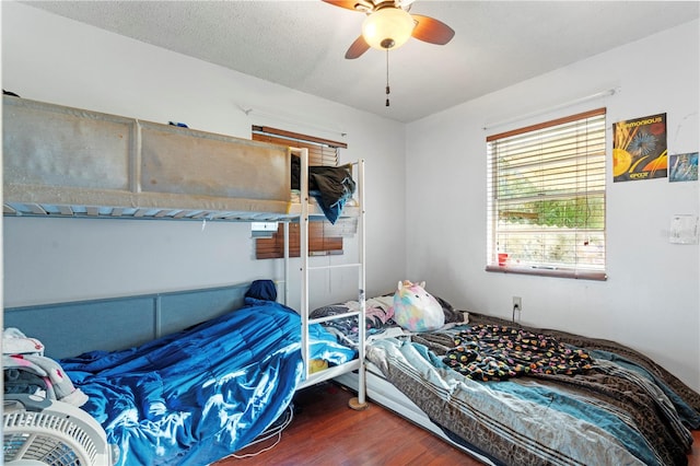 bedroom featuring a textured ceiling, dark hardwood / wood-style floors, and ceiling fan