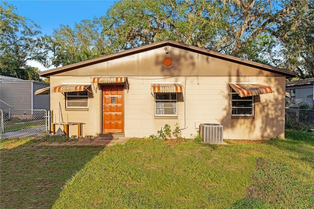 view of front of house featuring cooling unit and a front yard