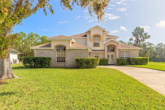 mediterranean / spanish home with a front lawn and cooling unit