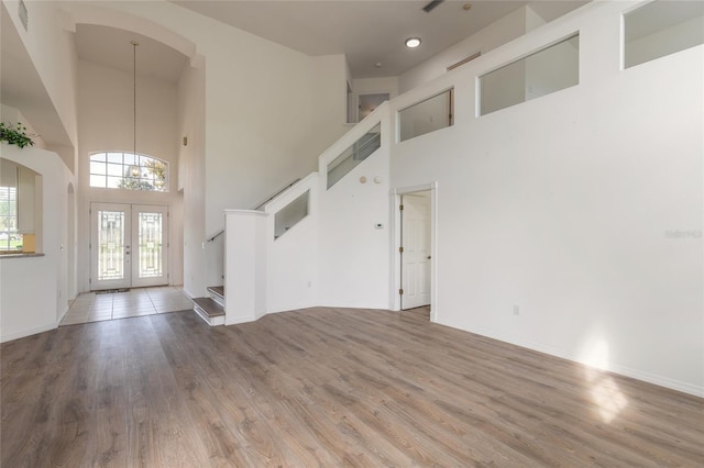 entryway with french doors, a high ceiling, and hardwood / wood-style flooring