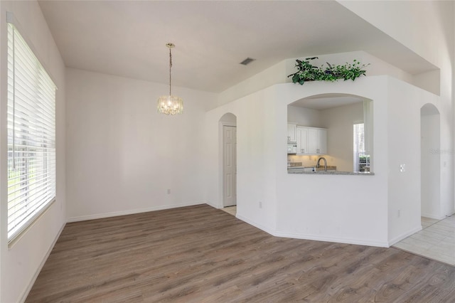 interior space featuring hardwood / wood-style floors, sink, and an inviting chandelier