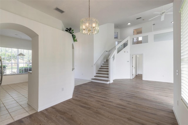 spare room featuring ceiling fan with notable chandelier and hardwood / wood-style flooring