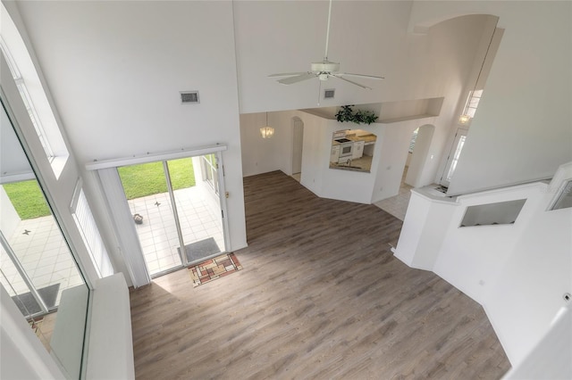 foyer featuring ceiling fan, a towering ceiling, and hardwood / wood-style flooring