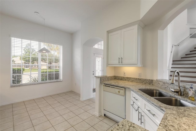 kitchen featuring pendant lighting, dishwasher, sink, light stone counters, and white cabinetry