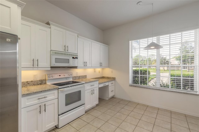 kitchen featuring white cabinetry, light tile patterned flooring, and white appliances