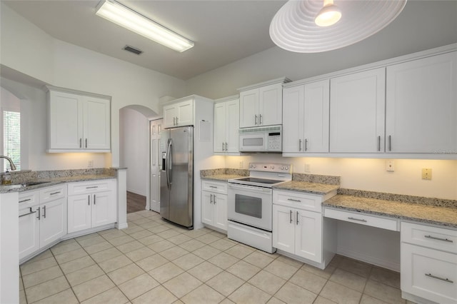 kitchen featuring white cabinets, light stone countertops, white appliances, and sink