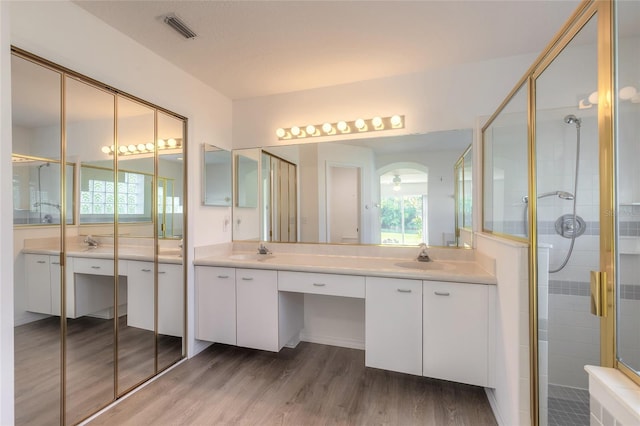 bathroom with radiator, a shower with door, vanity, and wood-type flooring