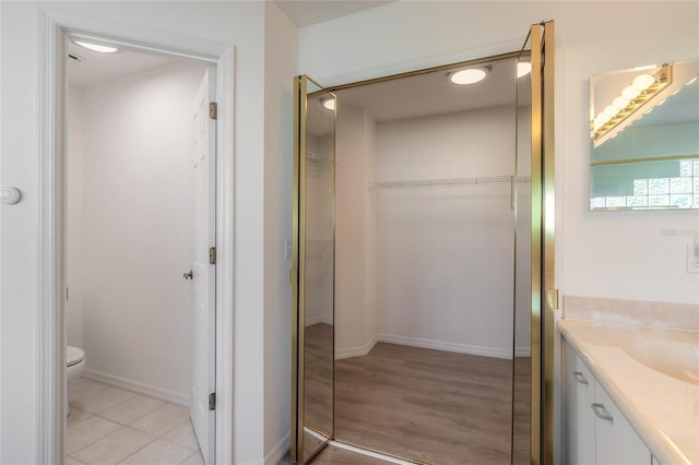 bathroom with wood-type flooring, vanity, and toilet