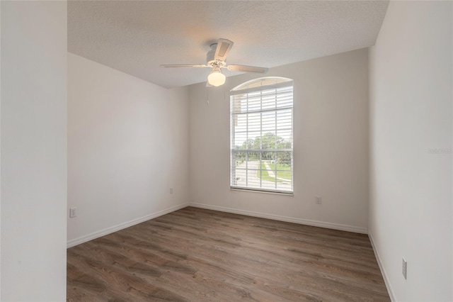 empty room with dark hardwood / wood-style floors, ceiling fan, and a textured ceiling