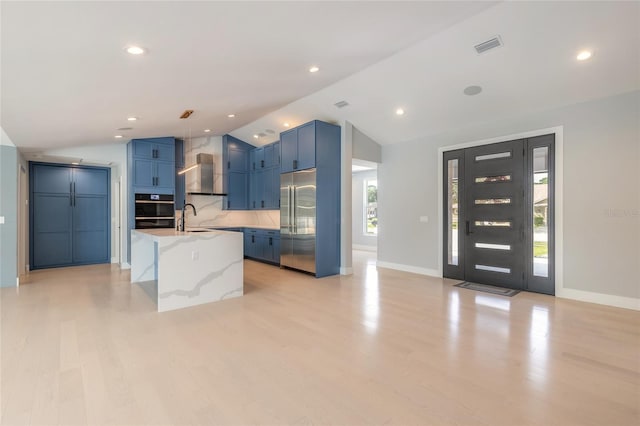 kitchen with plenty of natural light, blue cabinets, and built in refrigerator