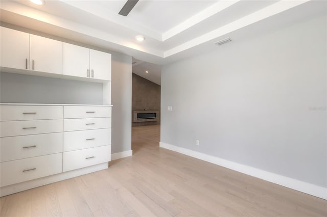 empty room featuring light hardwood / wood-style floors and a raised ceiling