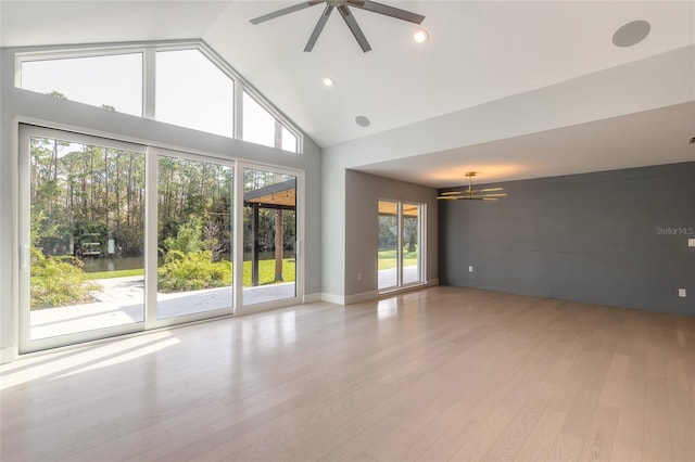 empty room with ceiling fan, light hardwood / wood-style floors, and high vaulted ceiling