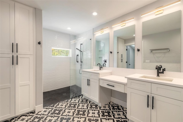 bathroom featuring a tile shower, vanity, and tile patterned floors