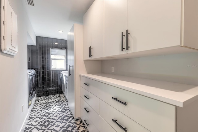 interior space featuring separate washer and dryer and white cabinetry