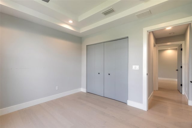 unfurnished bedroom with light wood-type flooring and a closet